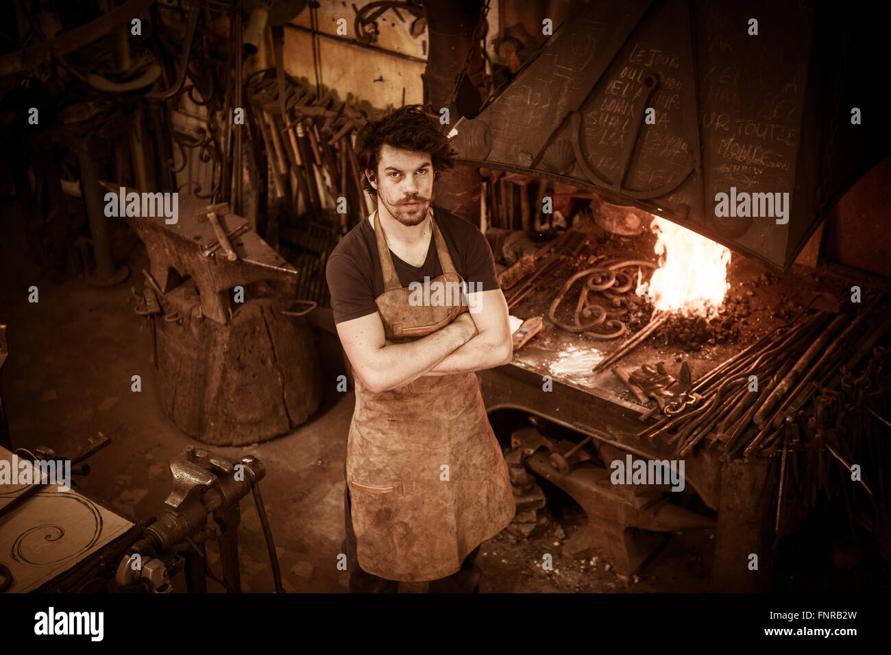 Stahlarbeiters heißen Eisen im Workshop schmieden Stockfoto