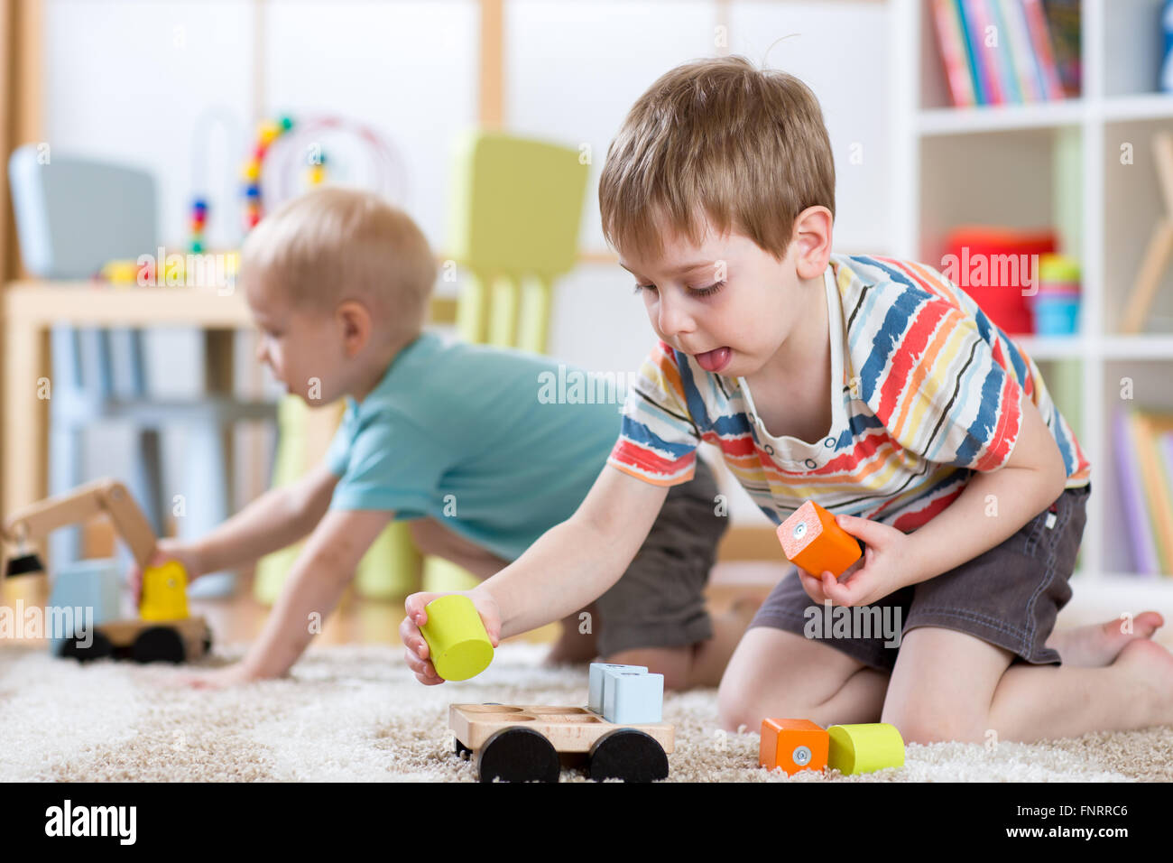 Kinder spielen mit Spielzeug im Kindergarten oder Kita oder zu Hause Stockfoto