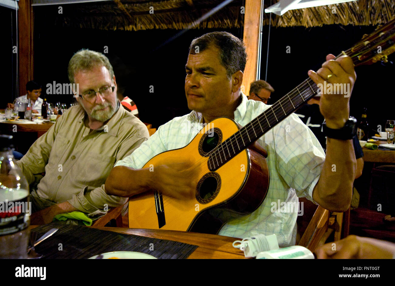 Präsident Rafael Correa Ecuador Serenaden Showmaster Peter Greenberg und seine Crew während des Abendessens nach Tag der Dreharbeiten im Amazonas für Ecuador: The Royal Tour. Stockfoto