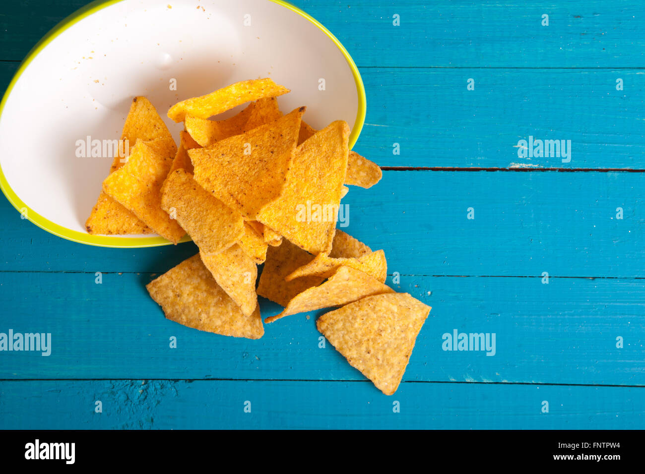 Mais-Chips zu verschütten aus den Platten auf dem Tisch Stockfoto