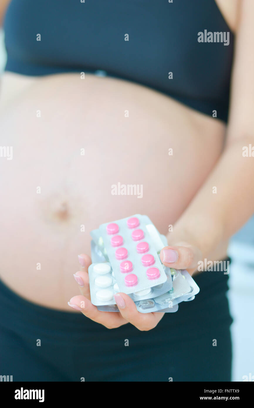 Schwangere Frau mit Drogen, Pillen und Kapseln in Blister-Packungen in der hand Stockfoto