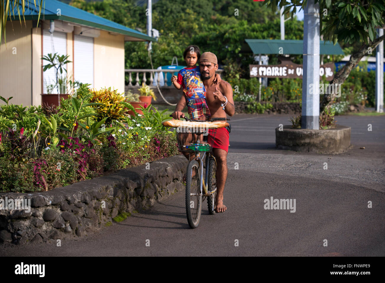 Tahitian Mann mit ihrer Tochter tragen Baguettes während der Fahrt ein Fahrrad auf der Insel Tahiti, Französisch-Polynesien, Tahiti Nui Stockfoto