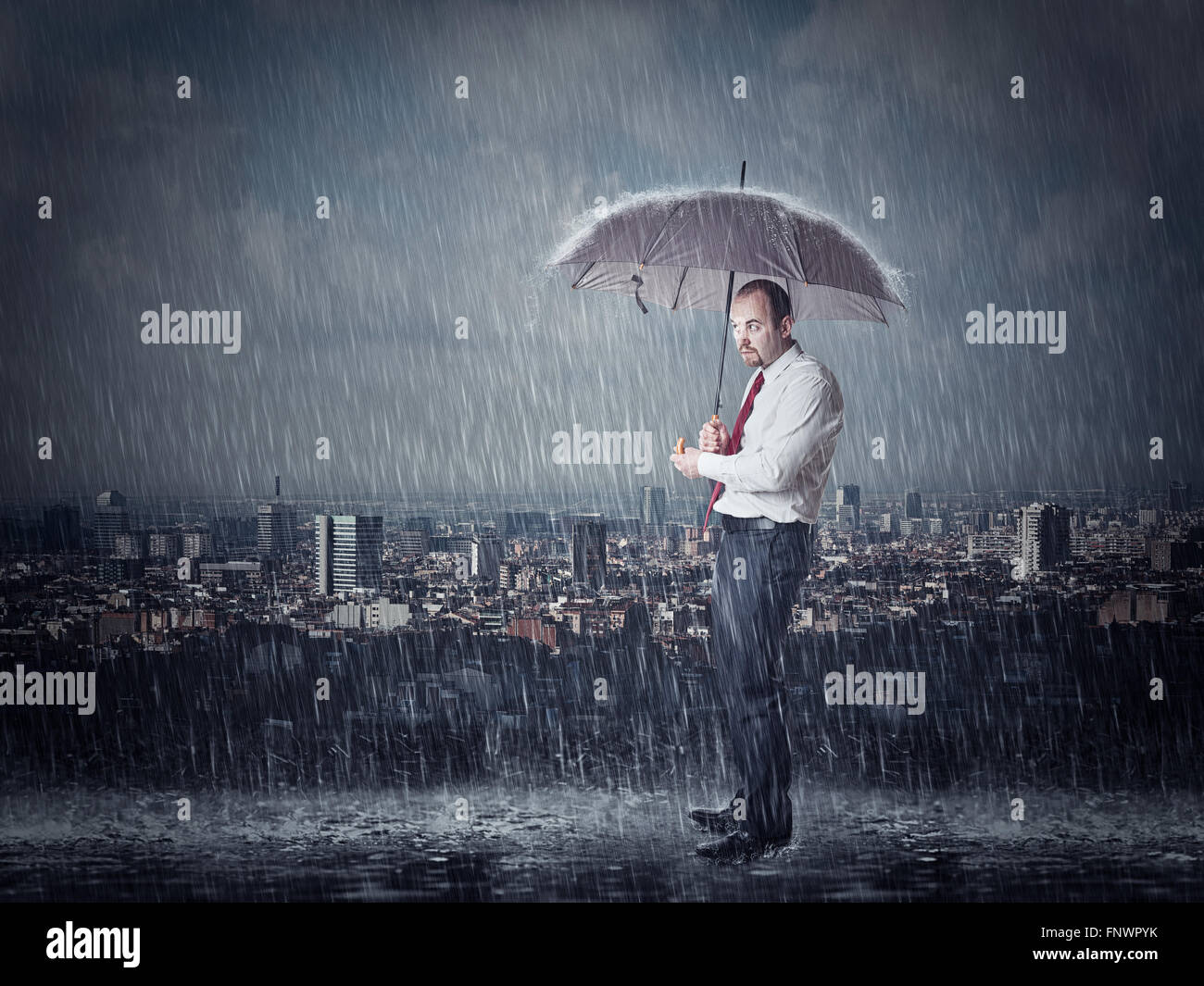 Mann mit Regenschirm und Starkregen städtischen Hintergrund Stockfoto