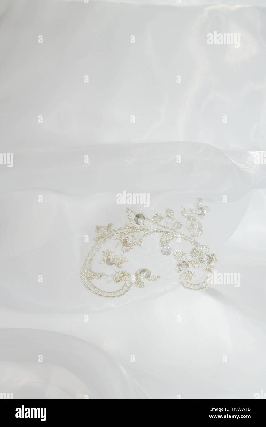 Stickerei mit Steinen auf ein weißes Hochzeitskleid Stockfoto
