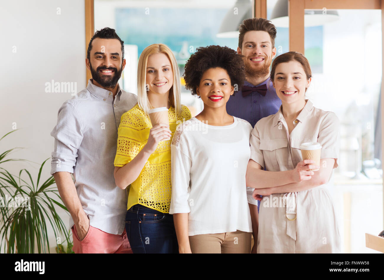 glücklich lächelnd Kreativteam mit Kaffee im Büro Stockfoto