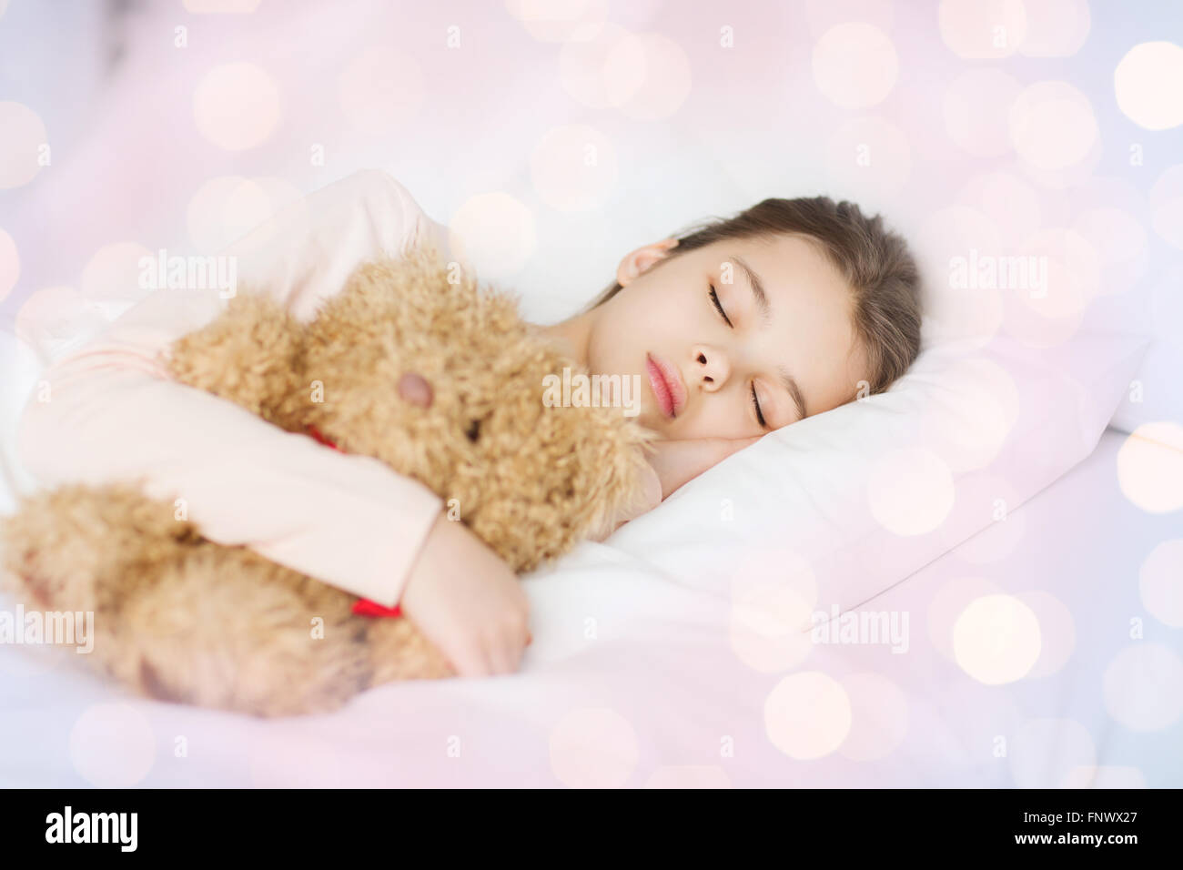 Mädchen mit Teddybär Spielzeug im Bett zu Hause schlafen Stockfoto