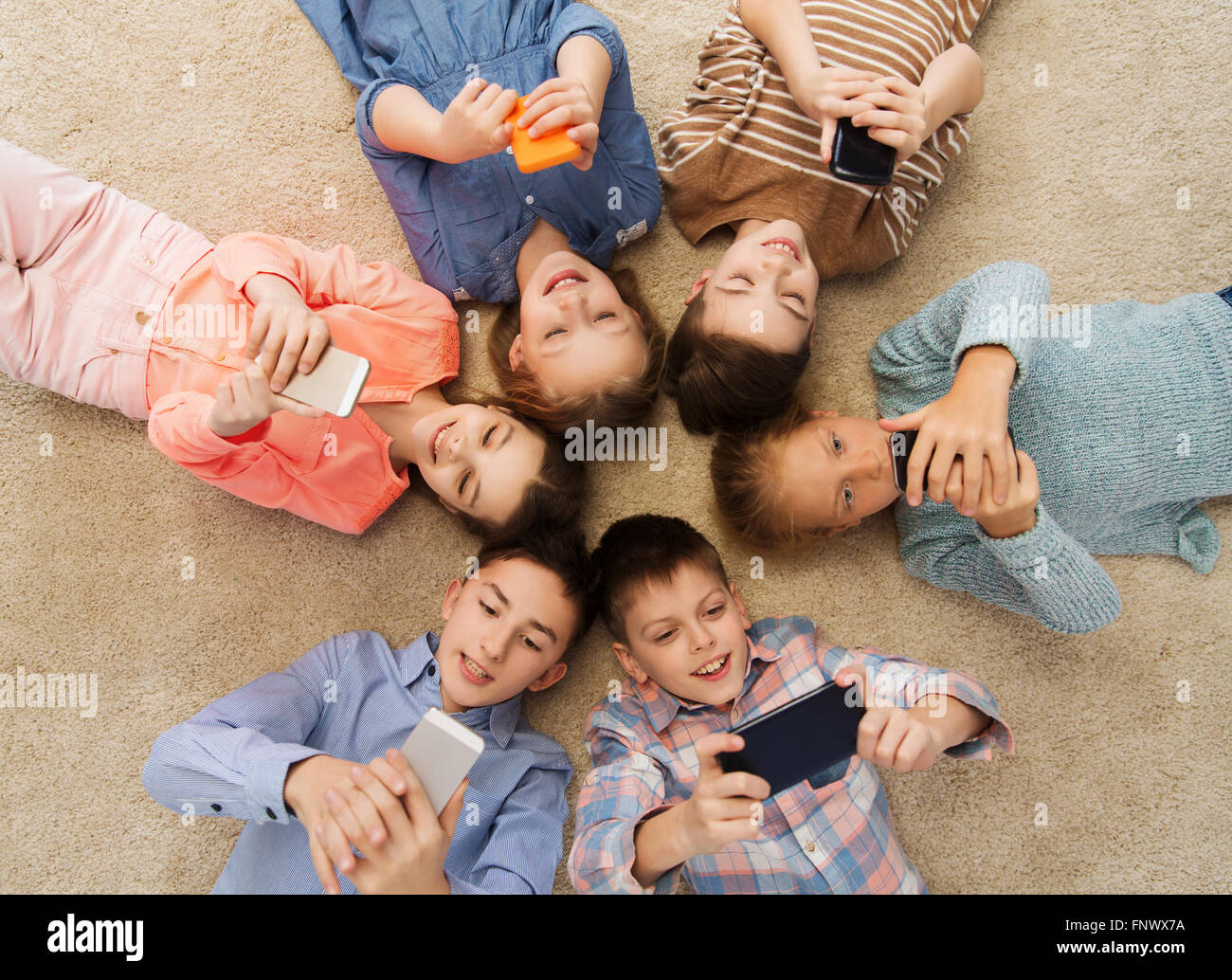 glücklich lächelnden Kindern auf Boden liegend in Kreis Stockfoto