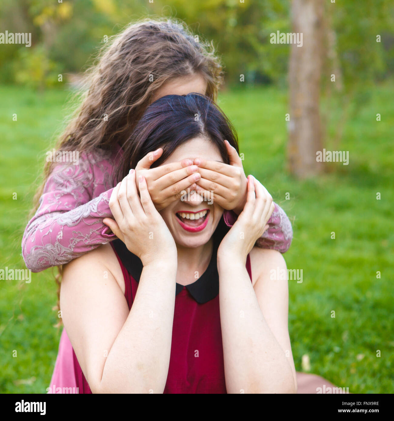 Tochter Mutter Schloß sie die Augen mit den Händen im park Stockfoto