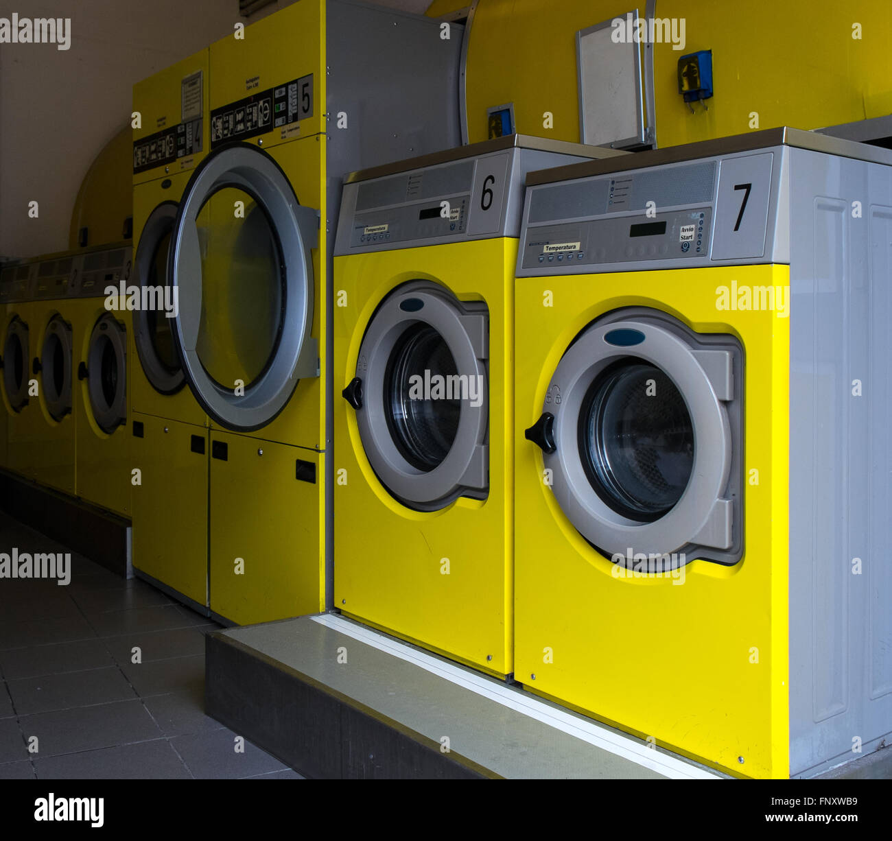 Gelbe Industriewaschmaschinen in einem öffentlichen Waschsalon Stockfoto