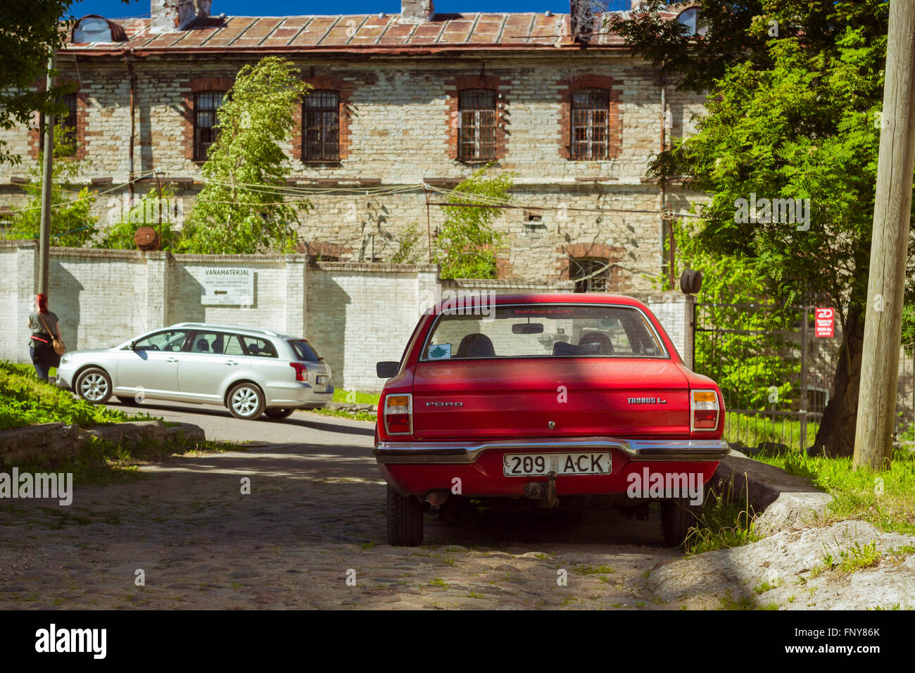 Tallinn, Estland - Yuni 12, 2015: Rote Oldtimer Ford Taunus auf Pflaster in einer verlassenen Straße geparkt. Sonnigen Sommertag Stockfoto