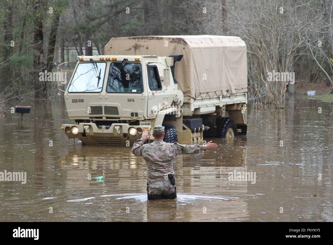 Ein Nationalgardisten leitet ein Hochwasser Träger hinunter eine überflutete Straßen, wie sie evakuieren Bewohner gefangen durch Hochwasser nach rekordverdächtigen Stürme Regen in den tiefen Süden 14. März 2016 in Grant Parish, Louisiana gedumpten. Stockfoto