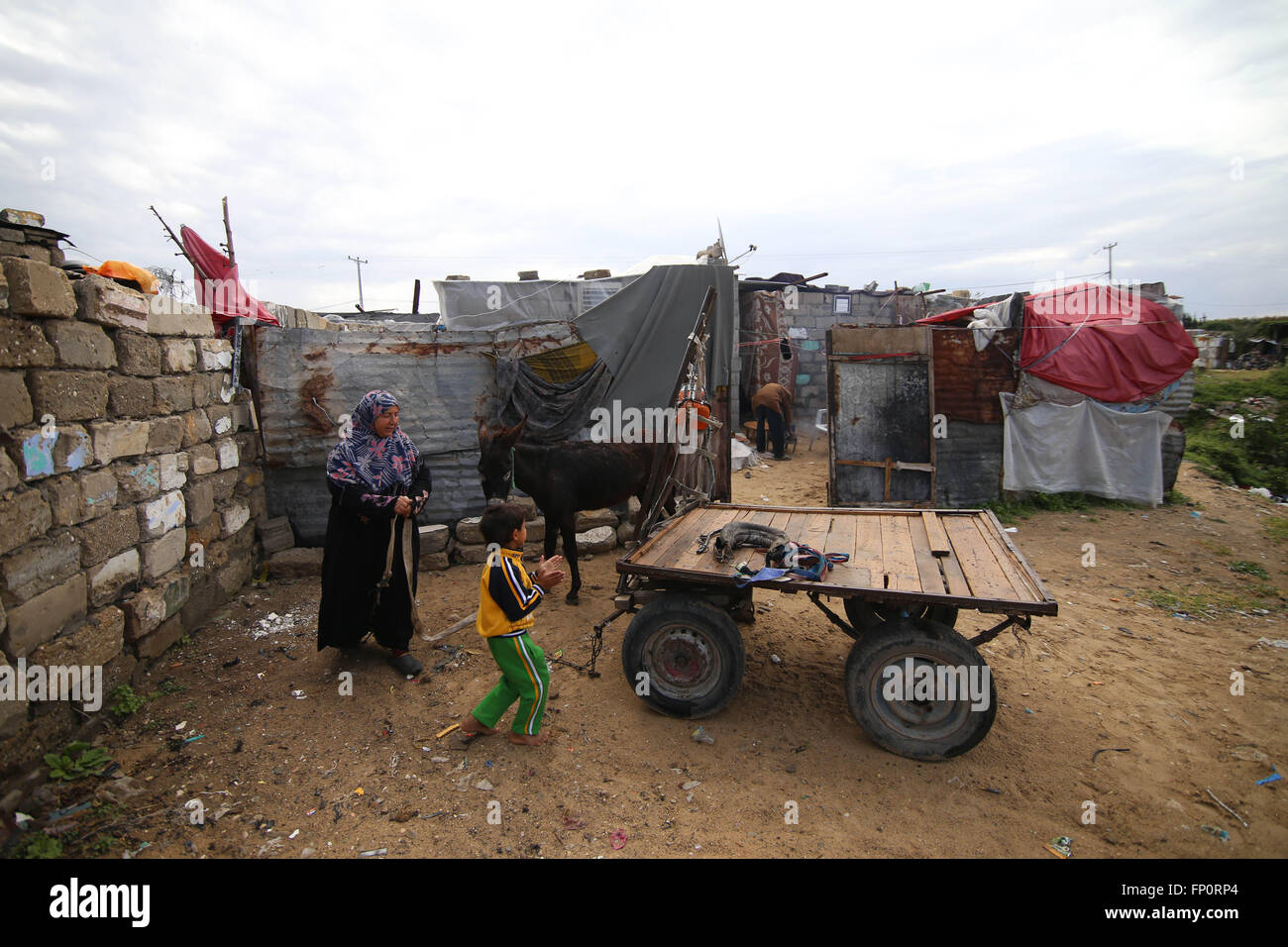 (160317)--GAZA, 17. März 2016 (Xinhua)--palästinensischen Jihan Moussa Abu Mohsen, 48, und ihr Sohn Ahmad, 10, bereiten Sie sich auf Felsen in den südlichen Gazastreifen Stadt von Khan Yunis, am 17. März 2016 zu sammeln. Jihan, der von den Morgenstunden bis spät am Tag arbeitet, verkauft einen Wagen voller Ziegel Stein Hersteller für 4 US-Dollar pro Tag. Ihre Arbeit ist die wichtigste Einnahmequelle für ihre Familie, die von ihrem Mann und vier Kindern besteht. Jihan und ihr Sohn Ahmad aufstehen jeden Morgen früh, Ziegeln und Steinen von überall zu sammeln, finden sie sie, ob in Deponien, Straßen oder Wegrändern. (Xinhua/Kha Stockfoto