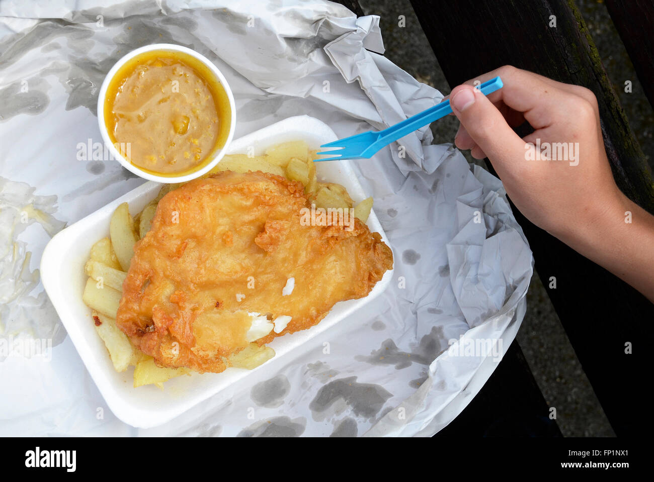Traditionelle britische Fish and Chips mit neben-Pot von curry-sauce Stockfoto