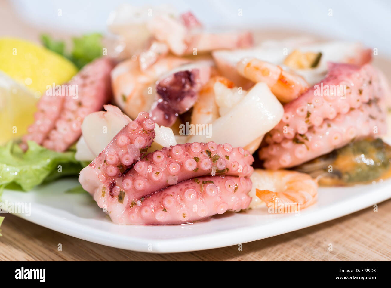 Portion Salat von Meeresfrüchten (Nahaufnahme) mit Tintenfisch, Muscheln und Garnelen Stockfoto