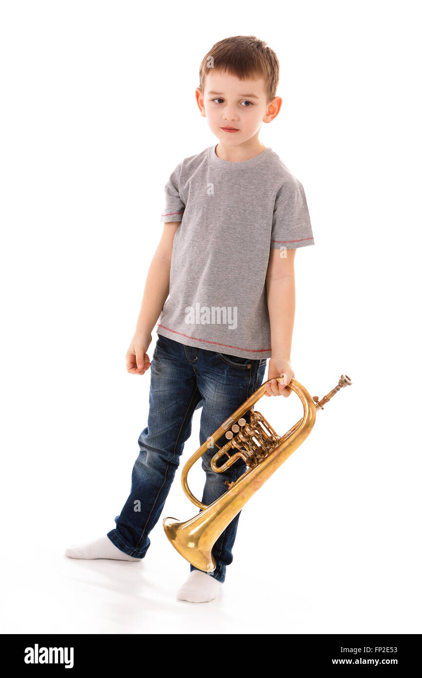 kleiner Junge bläst in eine Trompete vor weißem Hintergrund Stockfoto