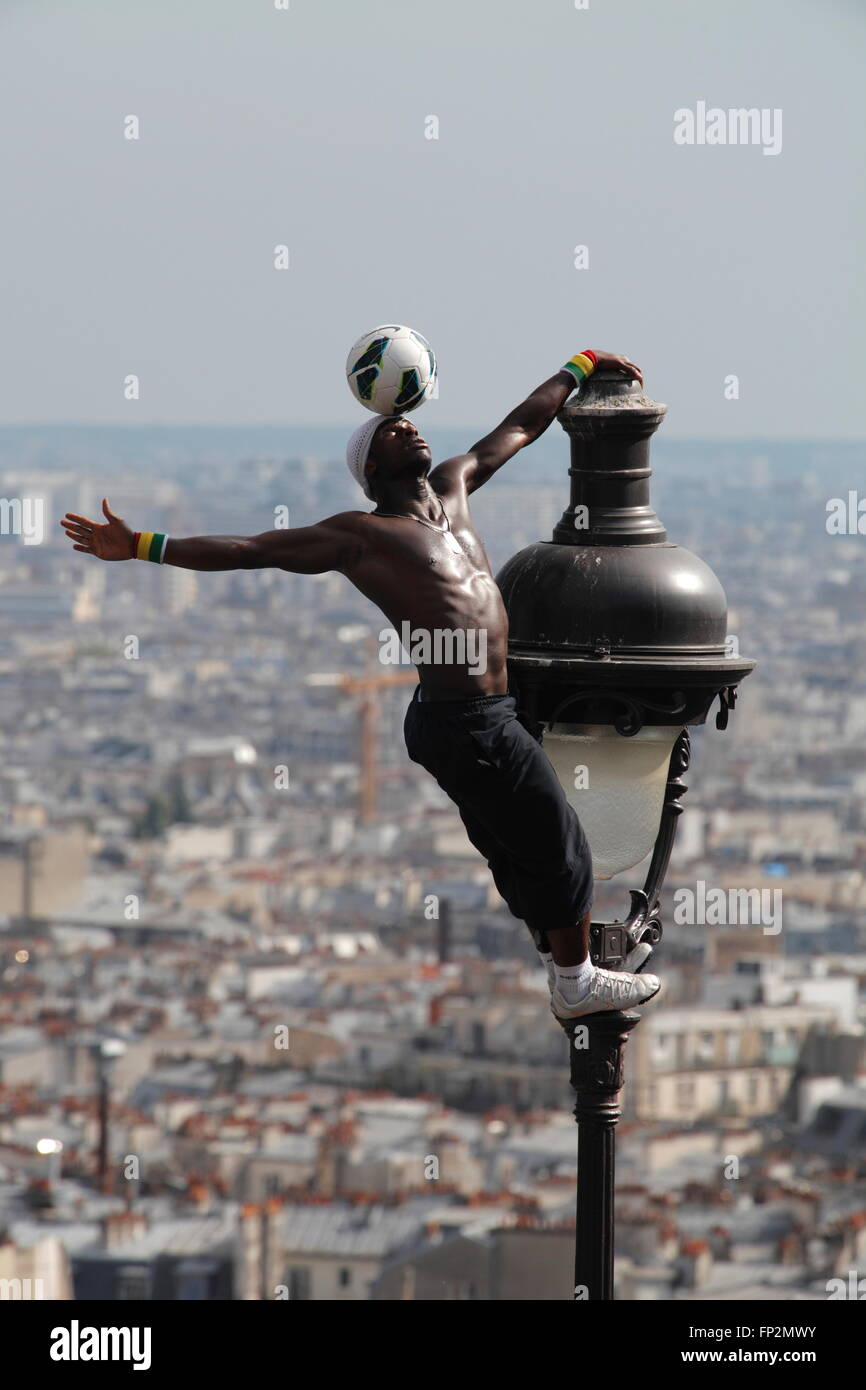 akrobatische Performance-Künstlerin in einem alten Gaslampe auf die Hügel von Sacre Coeur in Montmartre Paris Stockfoto