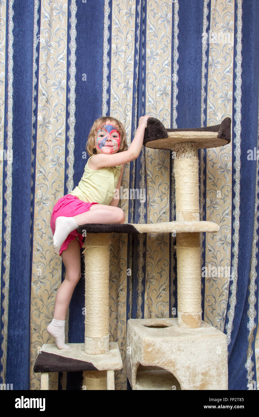 kleines Mädchen hängen an einer Katze klettern frame Stockfoto