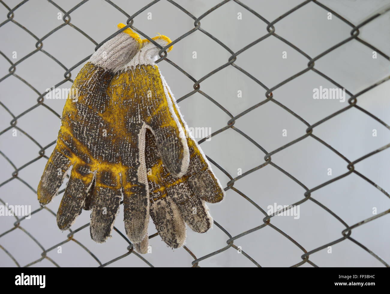 verschmutzte Handschuhe und Wire mesh soft-Fokus auf Handschuhe Stockfoto