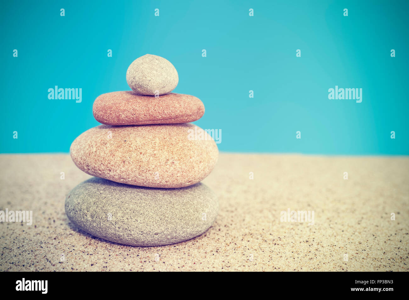 Retro stilisierte Steinpyramide auf Sand, Harmonie und Balance Konzept. Stockfoto
