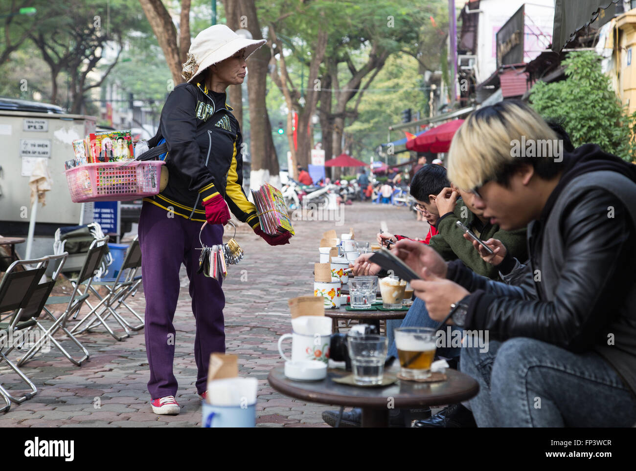 Asiaten Kaffeetrinken auf dem Bürgersteig in einem Franchise Cong Coffee Shop in der Hauptstadt Hanoi. Stockfoto