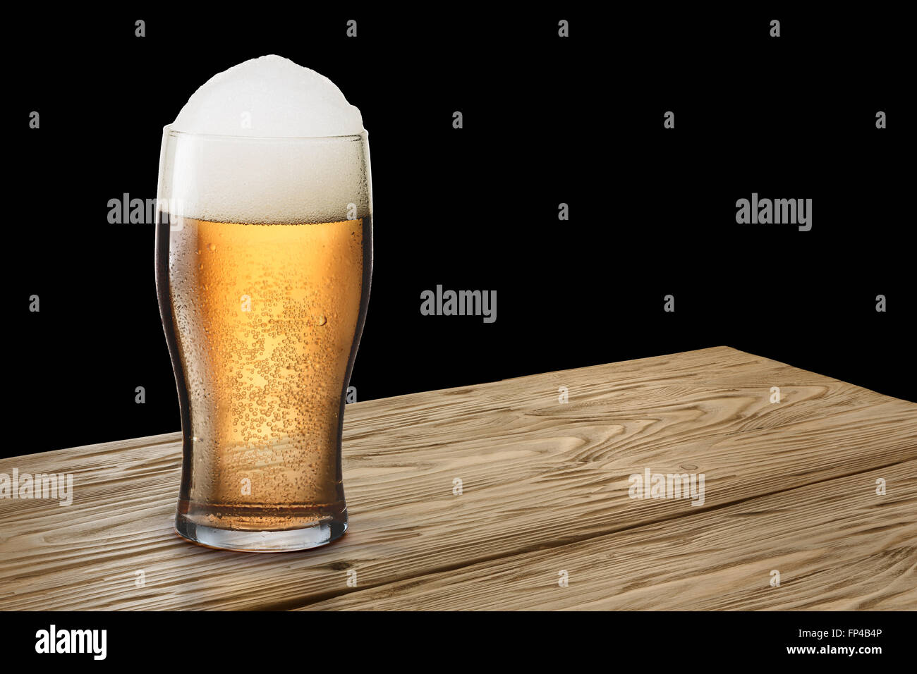 Feuchten Glas Licht, schäumende Bier mit Schaum auf entweder aus Holz Tisch oder Bar-Theke. Clipping-Pahts für Glas und Hintergrund Stockfoto
