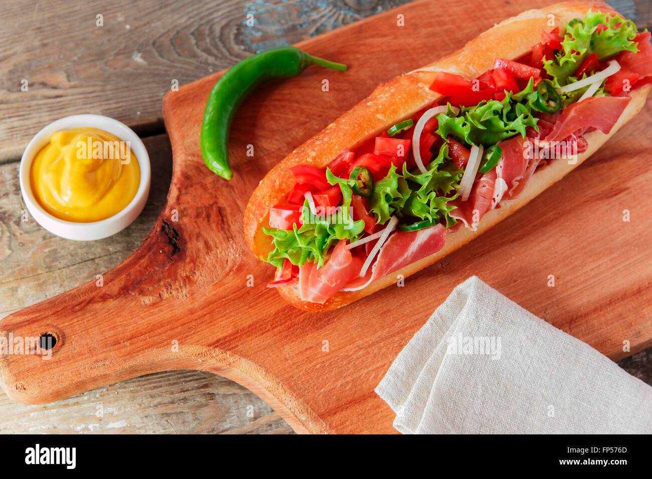 Sandwich Baguette Schinken Jamon mit Tomaten und Kräutern Stockfoto