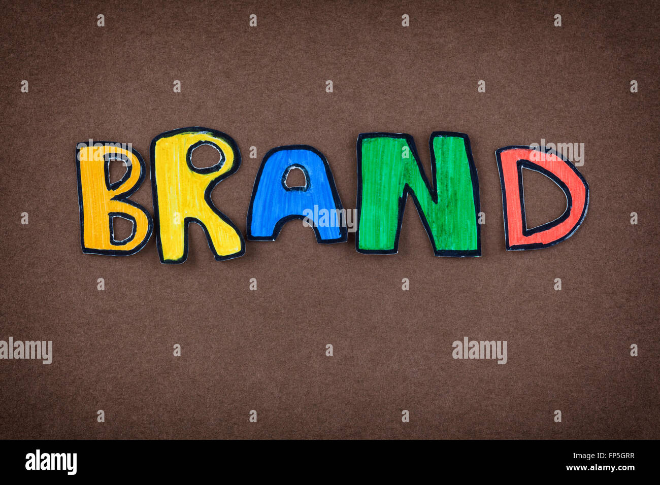 Farbiges Papier ausgeschnitten Wort Marke auf braunem Hintergrund. Stockfoto