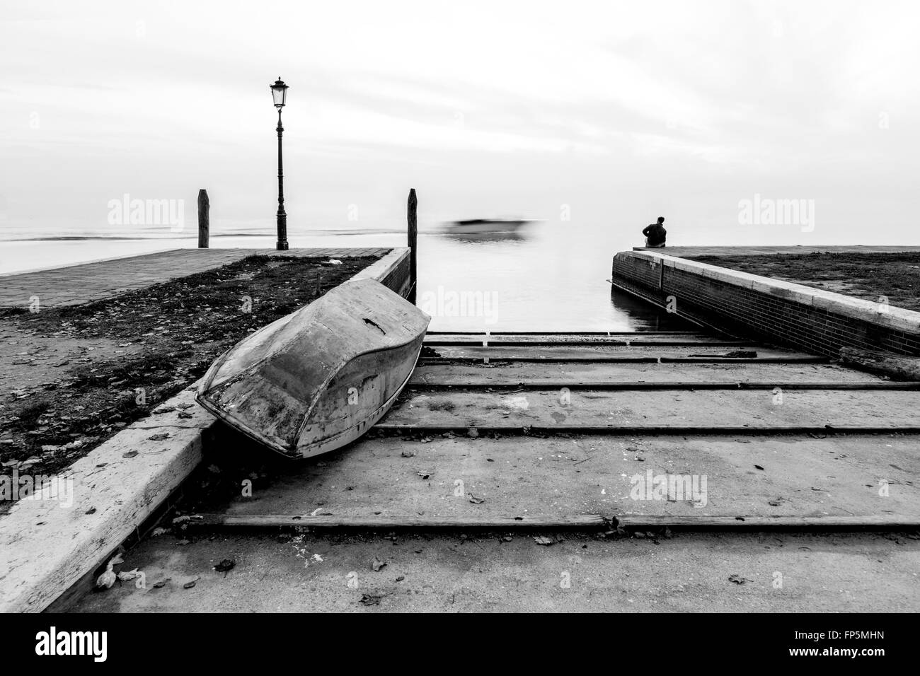 Der Mann schaut die Passage des Bootes in der Lagune Burano, Venedig, Venezia, Veneto, Italia, Italien Stockfoto