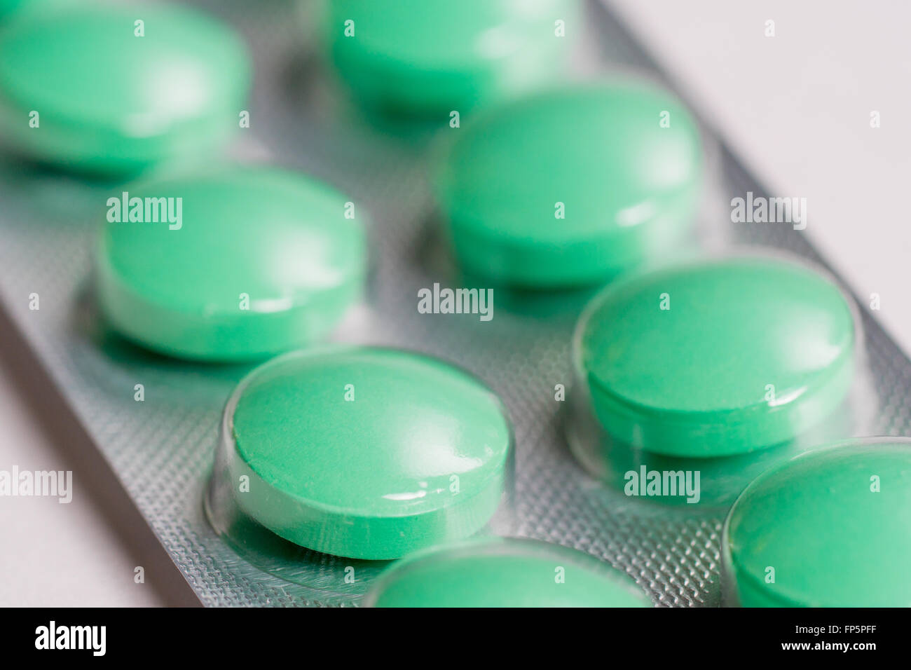 Nahaufnahme von acht grünen Pillen im blister Stockfoto