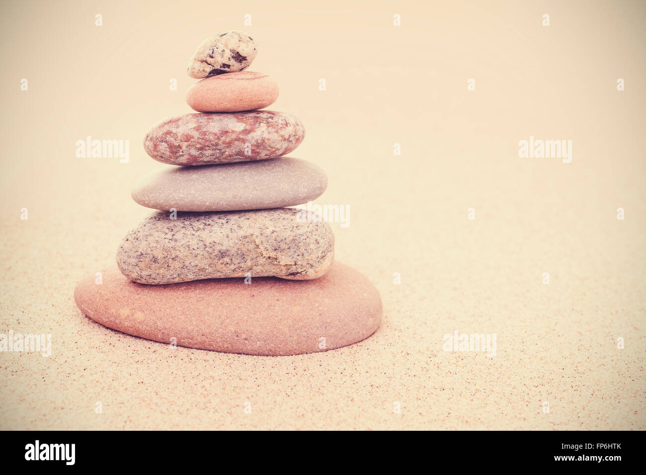 Sepia Retro stilisierte Steinpyramide auf Sand, Harmonie und Balance Konzept. Stockfoto