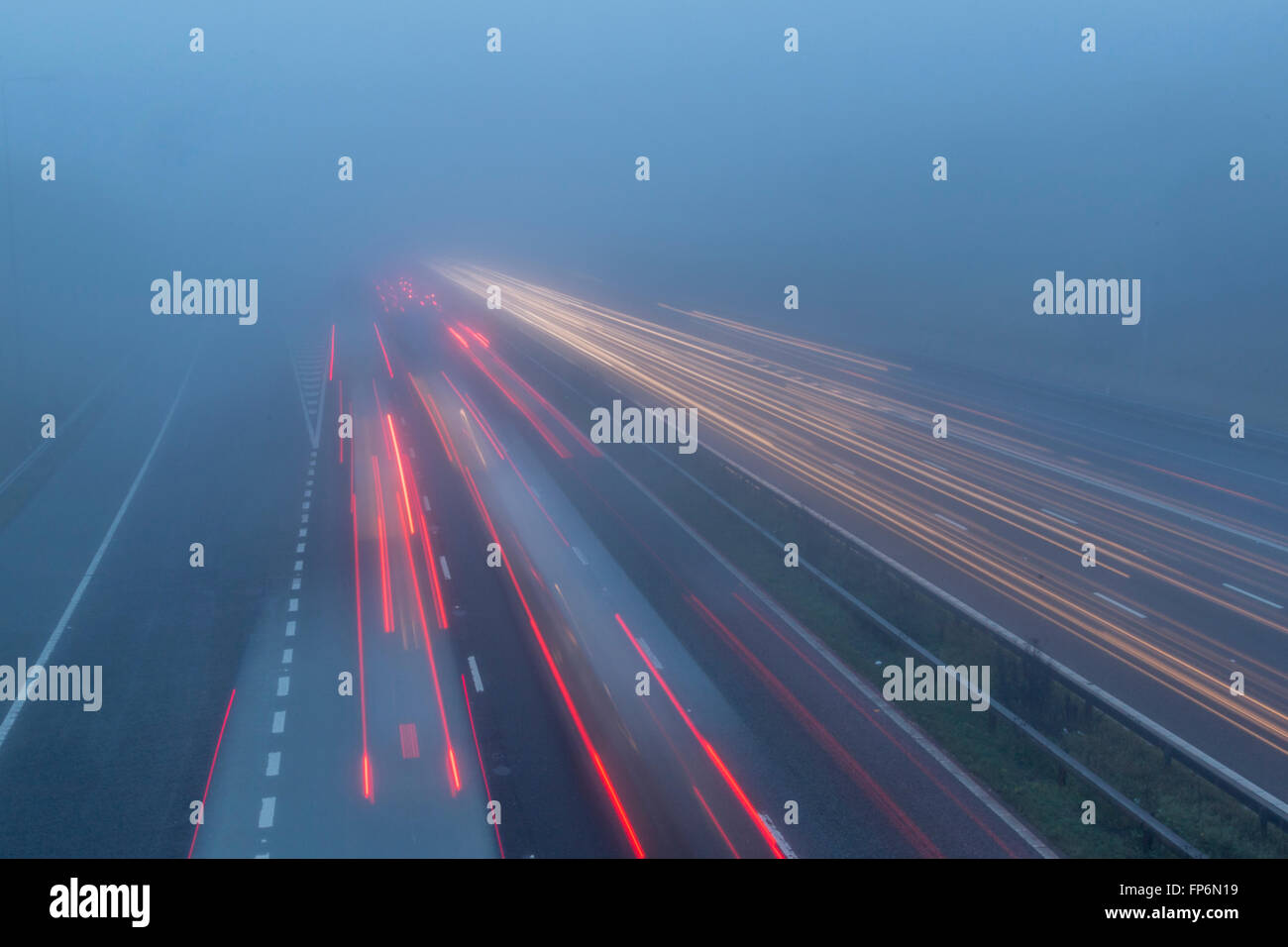 Ein nebliger Tag auf der Autobahn mit Lichtspuren. Stockfoto