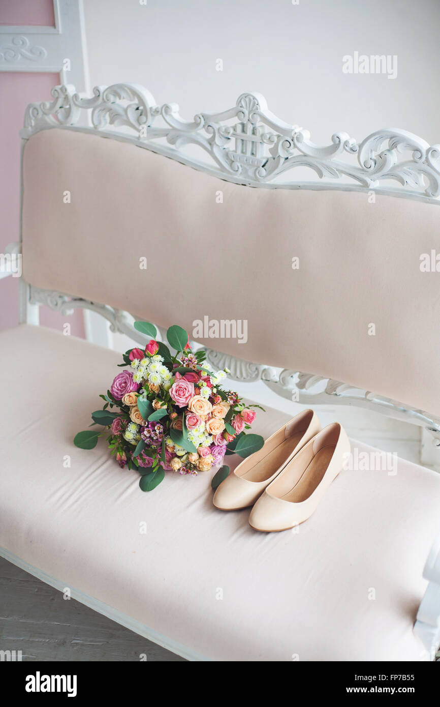 Frauen Schuhe und Blumenstrauß auf Sofa im schönen Innenraum Stockfoto