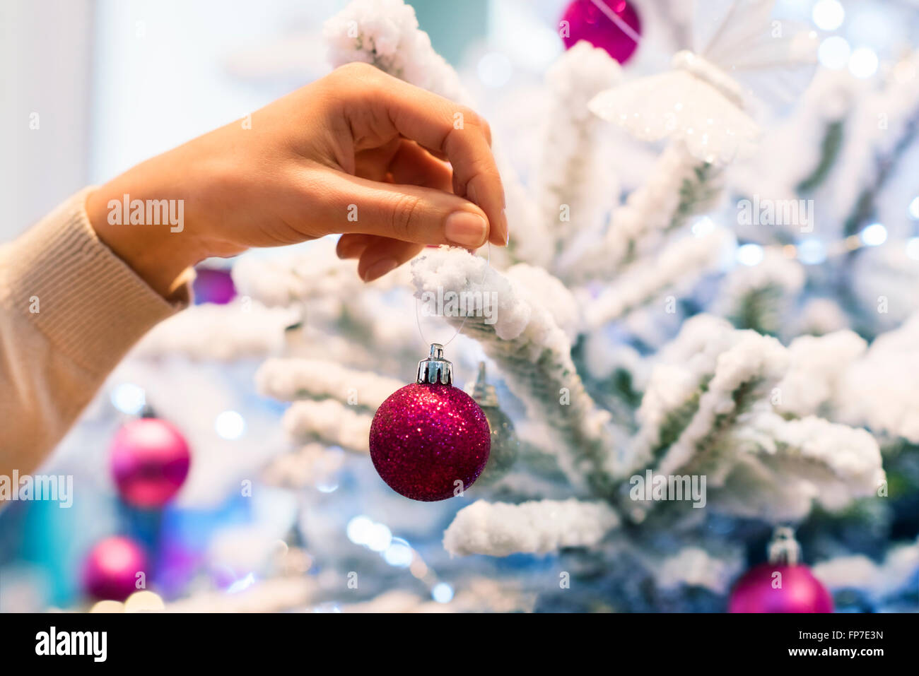 Frau zu Hause dekorieren Weihnachtsbaum. Close-up Hände Stockfoto