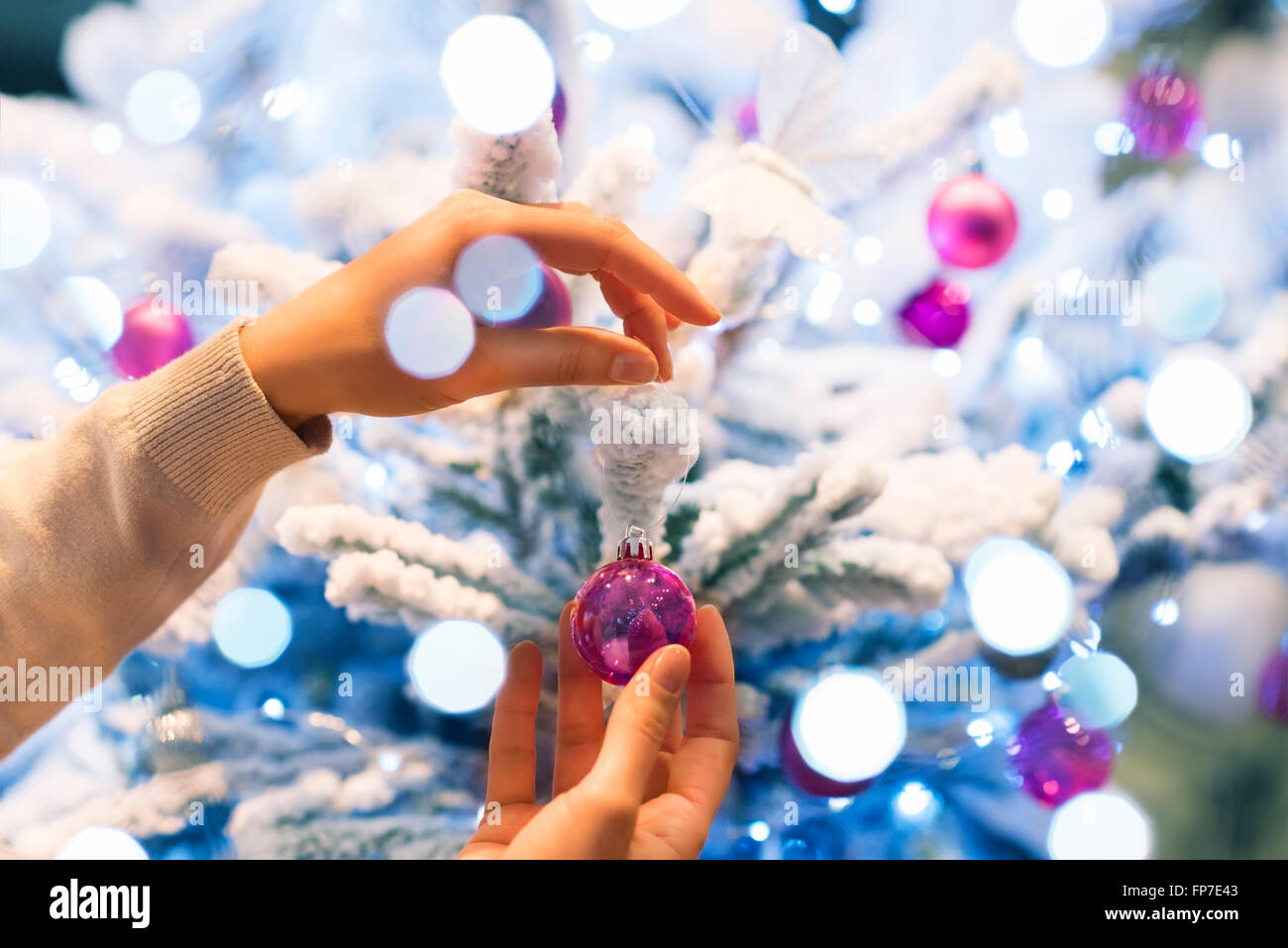 Frau zu Hause dekorieren Weihnachtsbaum. Close-up Hände Stockfoto