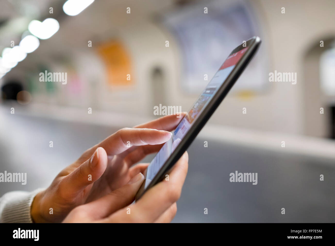 Frau mit ihrem Handy auf leere Plattform u-Bahnstation. App, Sms, Nachrichten, e-Mail, SMS Stockfoto