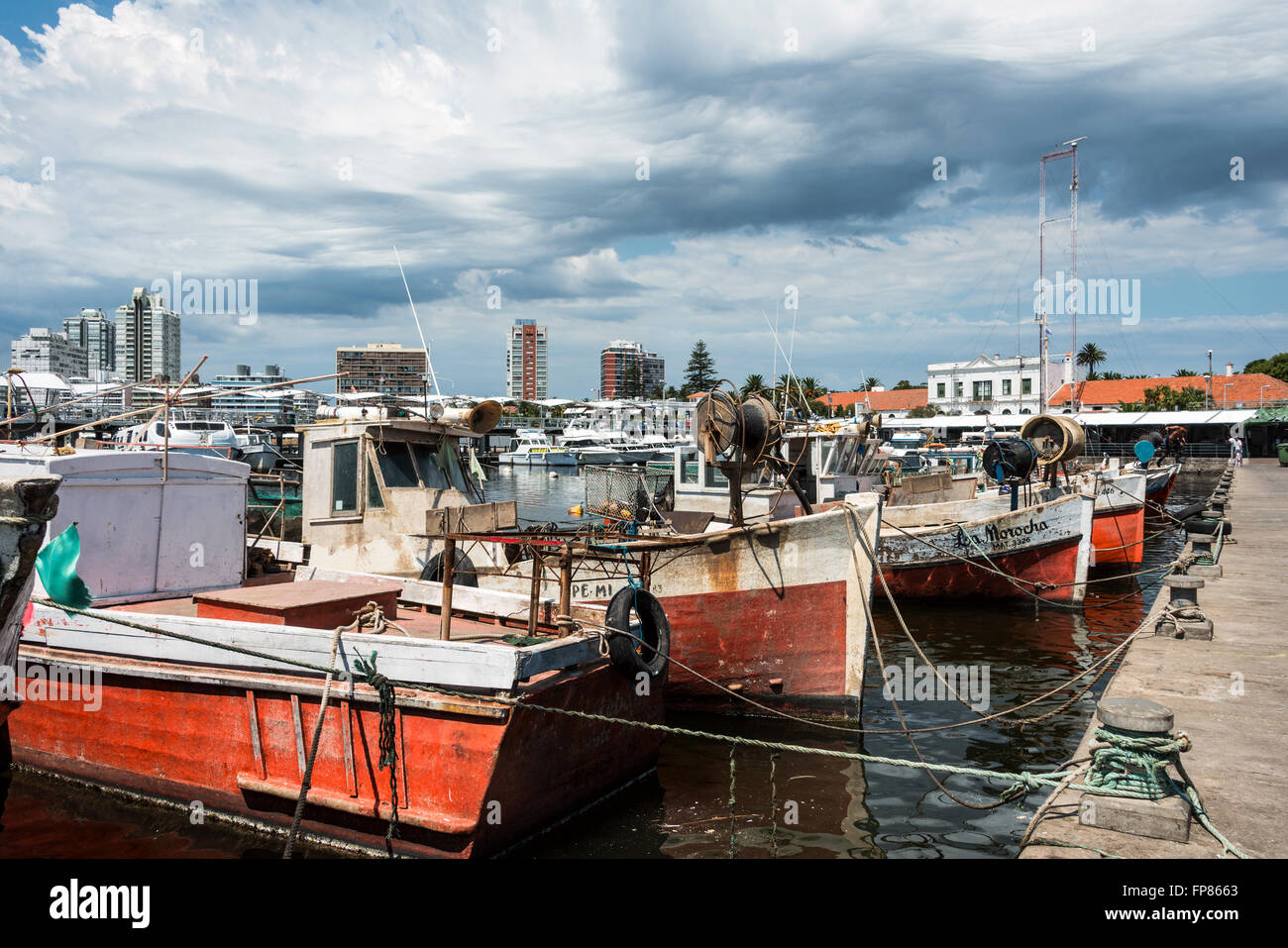 MALDONADO, 29. Februar 2016 - Classic Red Angelboote/Fischerboote vertäut vor die Yachten der reichen Leute in Punta del Este har Stockfoto