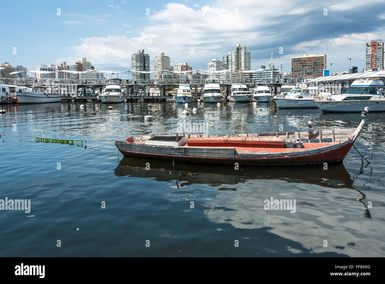 Angelboot/Fischerboot rot und Yachten der reichen Leute in Punta del Este, Uruguay Stockfoto