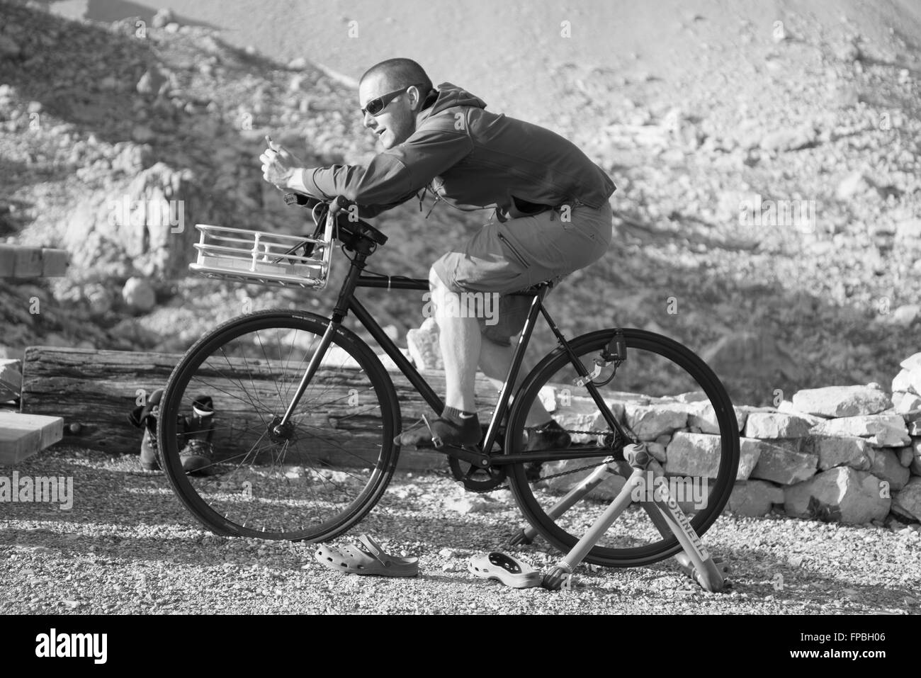 Junger Mann auf einem Fahrrad zum Aufladen von Handy-Akkus vor dem Mount Sulzfluh an der Carschina Hütte, Graubünden, Schweiz Stockfoto