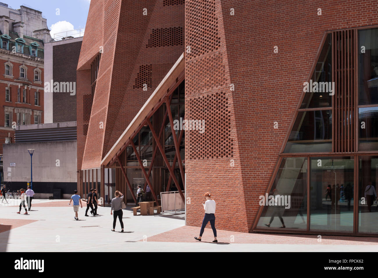 Die scharfen Winkel Mauerwerk und Glas Eingang des LSE Student Centre designed by O'Donnell & Tuomey Architekten, mit Passanten. Stockfoto