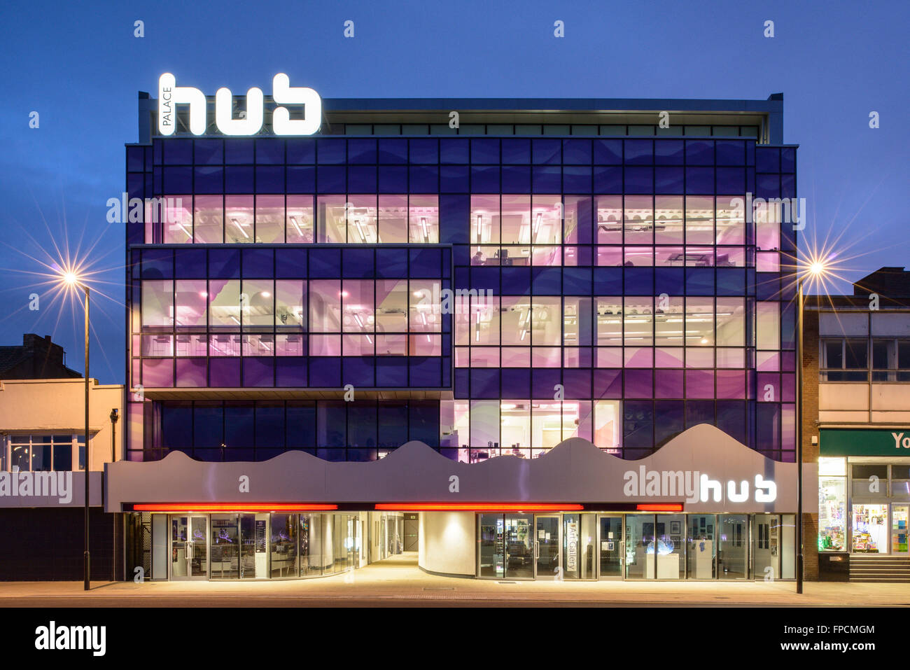 Eine Außenansicht der ultra modernen Palast-Nabe, die große Glasfront mit Neon beleuchtete zu beenden. In der Nacht genommen. Stockfoto