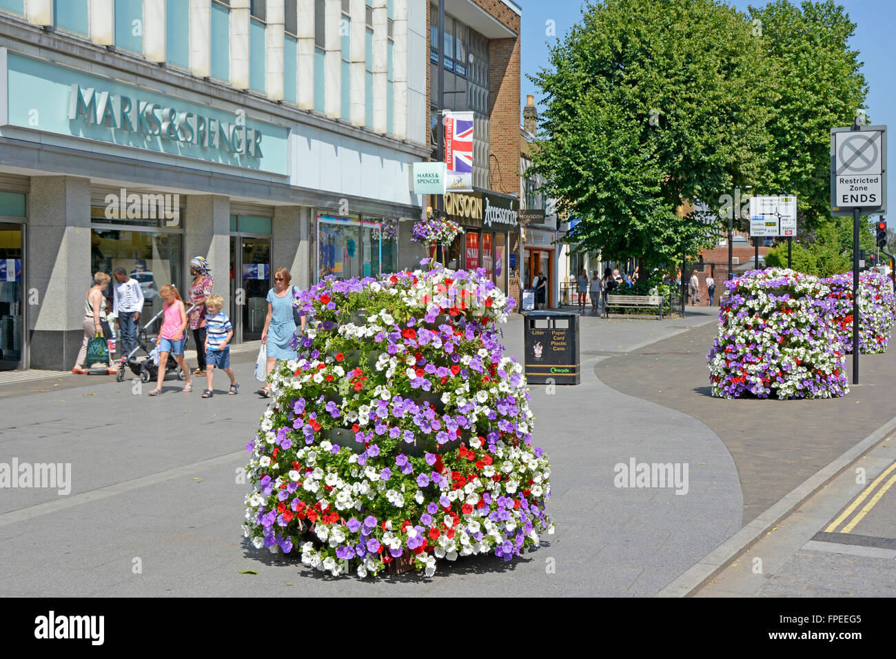 Brentwood Essex Shopping High Street Sommer Blumenanzeige in Pflanzer Vor dem Marks & Spencer Kaufhaus auf Wide Bürgersteig England GB Stockfoto