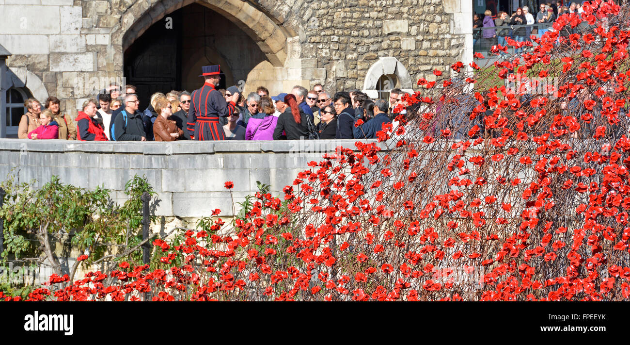 Überlappende Bereich der Keramik Mohnblumen "Blut fegte Ländereien & Meere rot" 1. Weltkrieg Tribut Tower of London mit Yeoman Warder Tour für Gruppe von Touristen Stockfoto