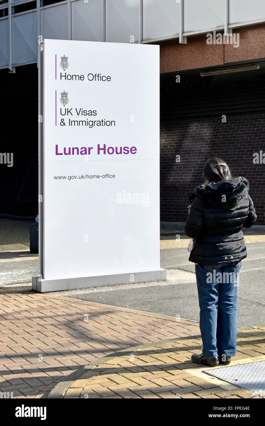 Unbekannte Person mit unbekanntem Wohnsitzstatus vor dem Home Office schaut Schild Regierungsbüros Lunar House Croydon South London England Großbritannien Stockfoto