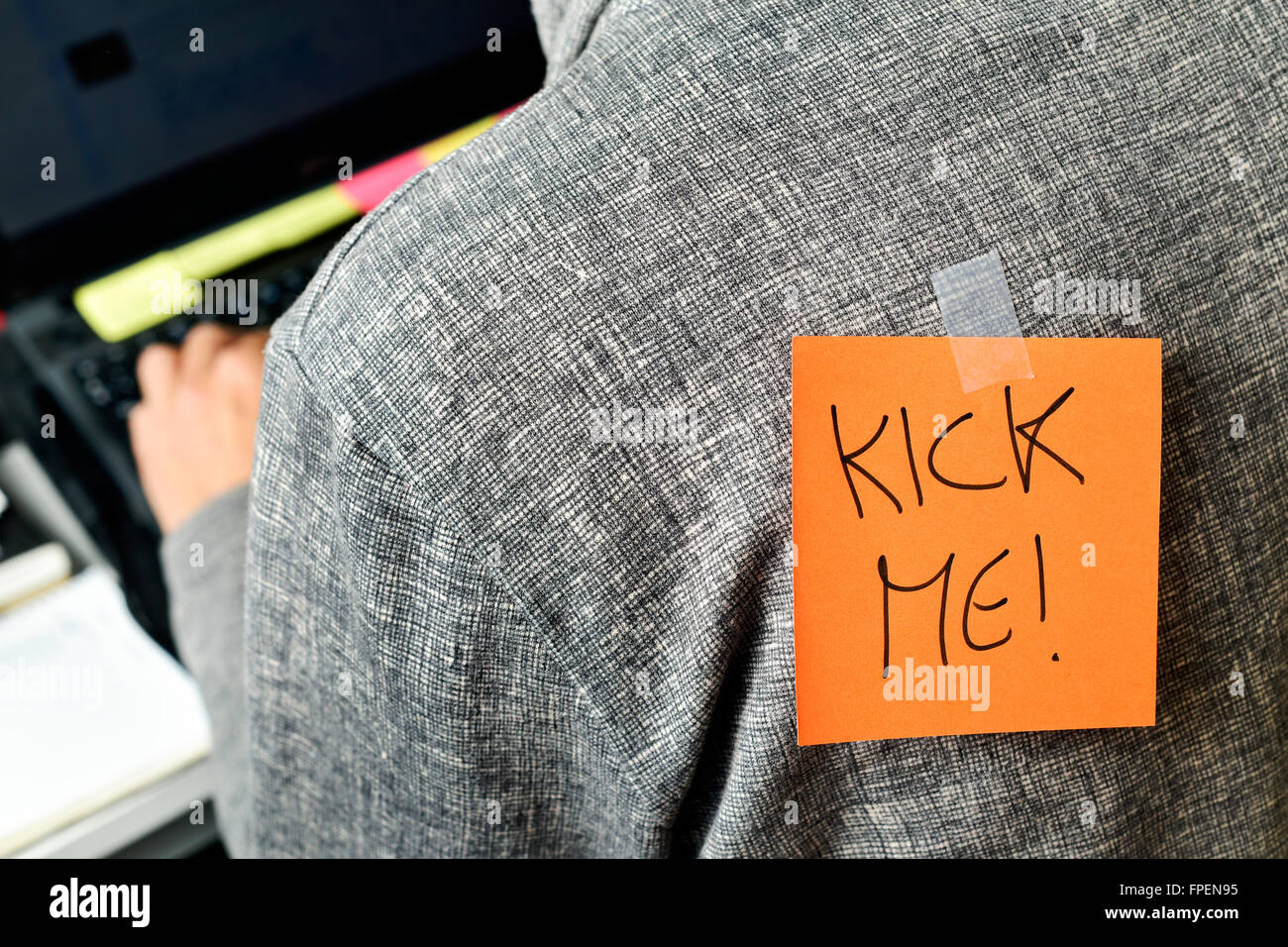 Nahaufnahme eines jungen Mannes mit einem Papier mit dem Text tritt mich auf seinem Rücken befestigt Stockfoto
