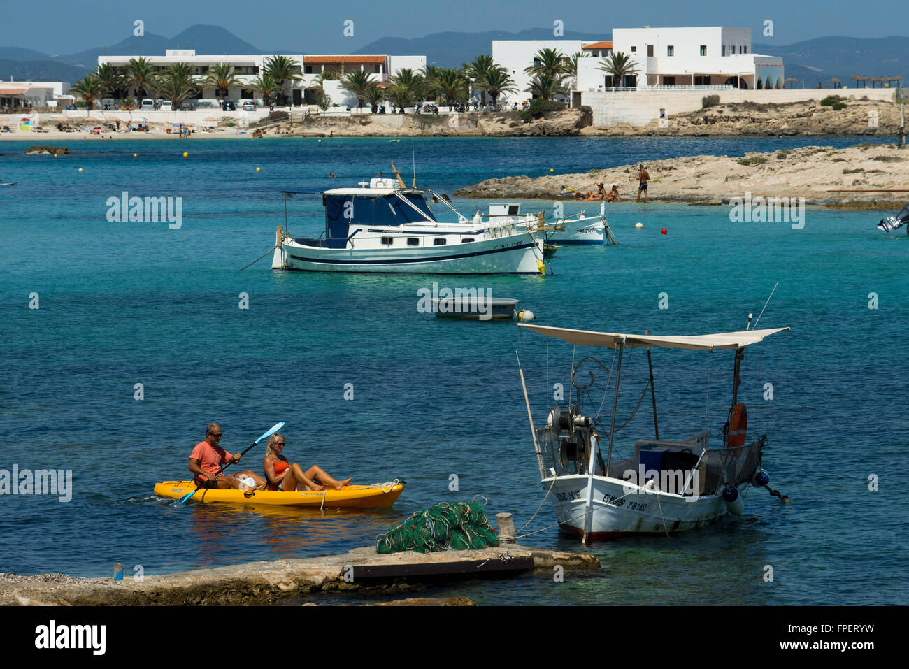 ELS Pujols Strand auf Formentera mit traditionellen Fischerboot und Kajaks im Sommertag. Llaüt Boote. Stockfoto