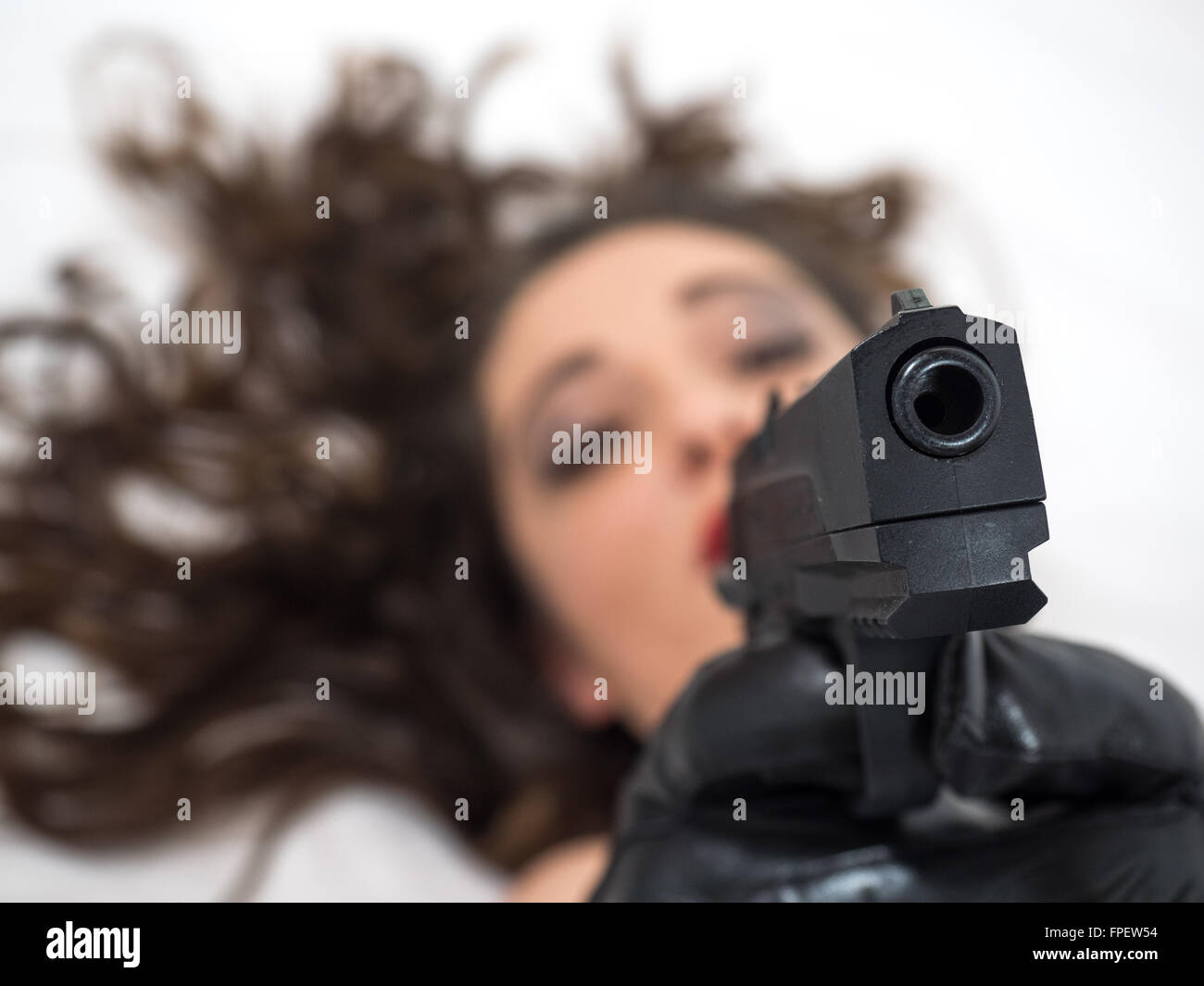 Mädchen liegend konzentrieren mit einer Pistole, sich auf die Waffe Stockfoto