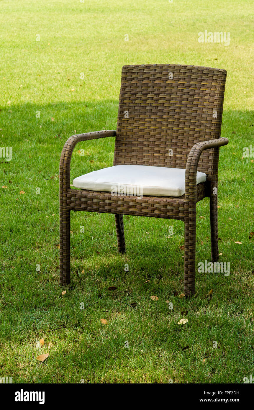 Braun Rattan Stuhl mit Kissen im Garten Stockfoto