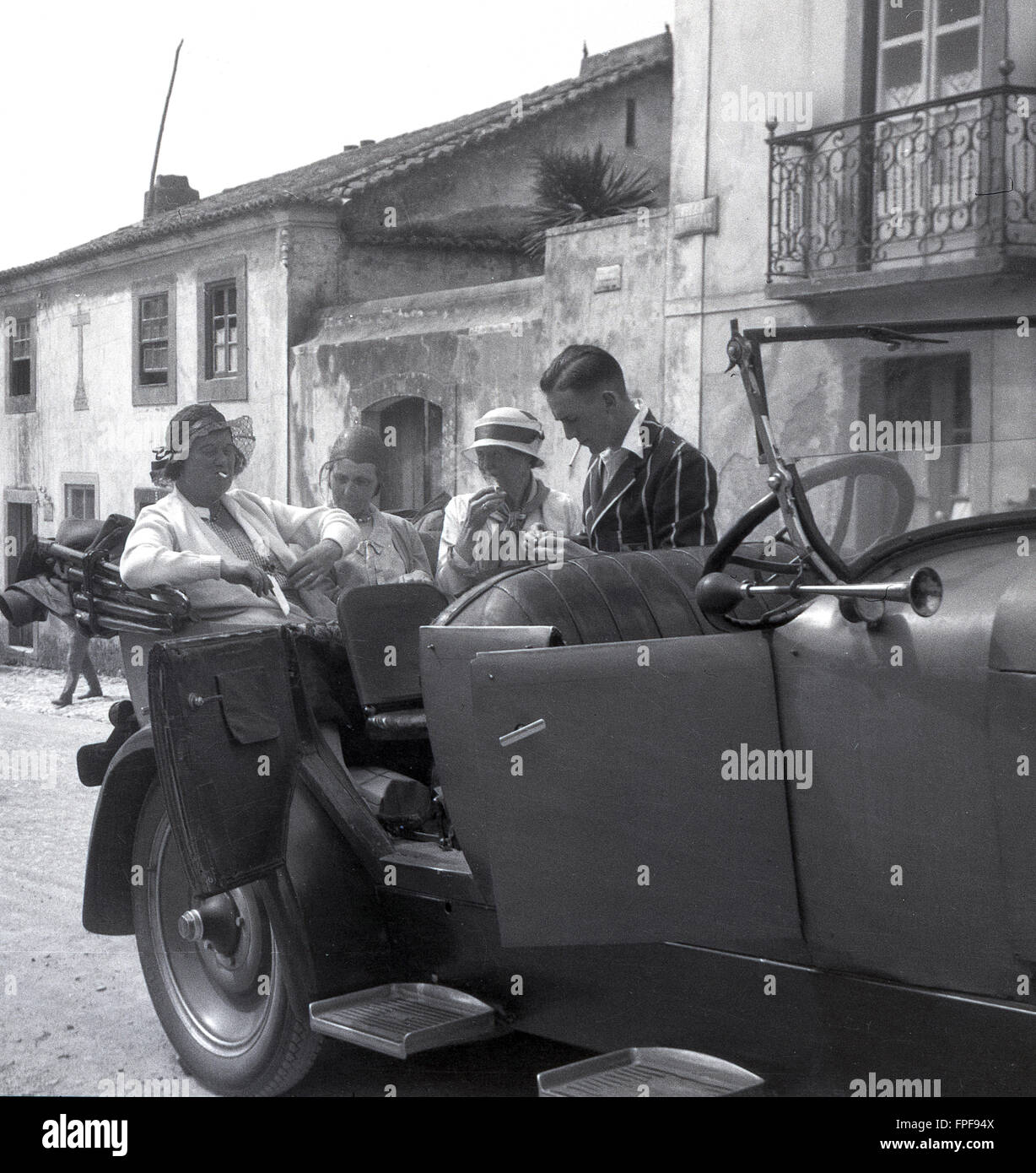 1930er Jahre historische, Menschen auf eine Grand Tour of Europe in einem offenen gekrönt Wagen eine Zigarette genießen. Stockfoto