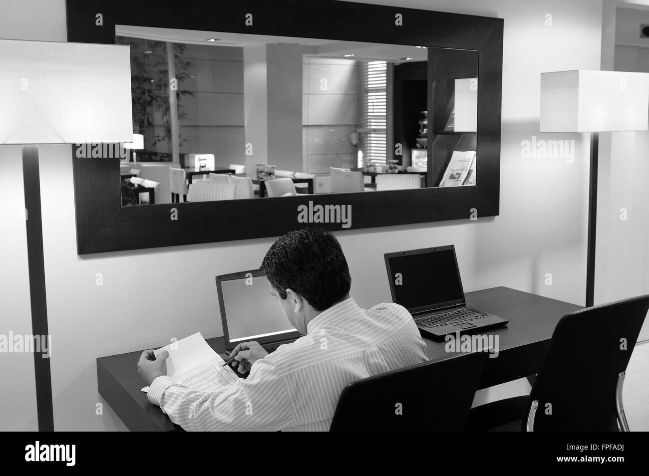 Mann arbeitet in einer Hotelrezeption. Schwarz / weiß Stockfoto