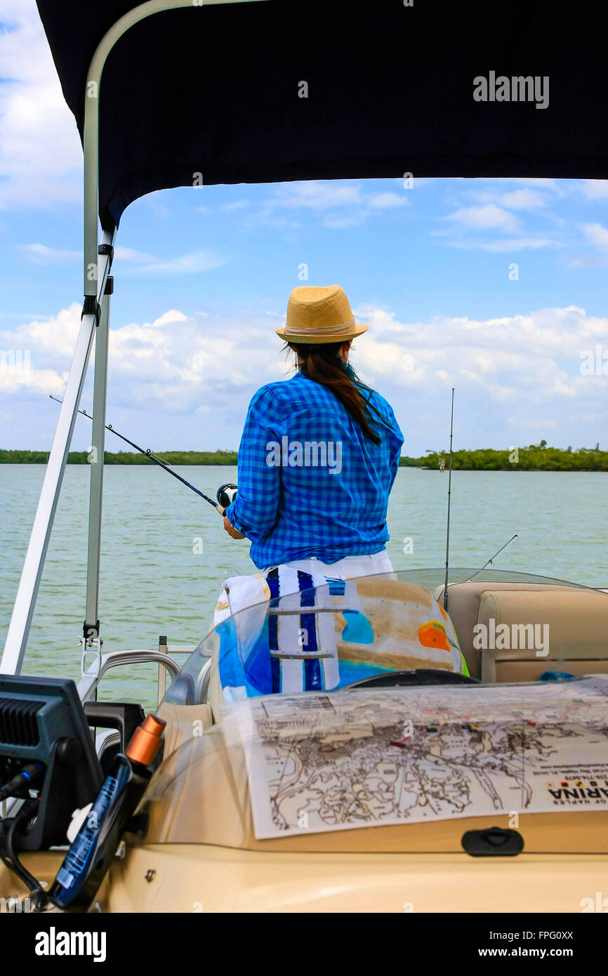 Erwachsene weibliche Angeln von einem Boot in Marco Bay, Florida Stockfoto
